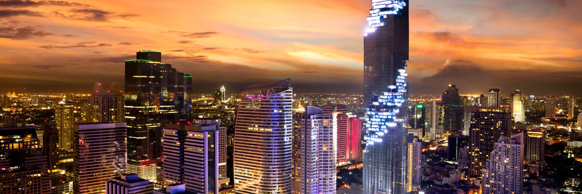 A city skyline at dusk under a gold evening sky