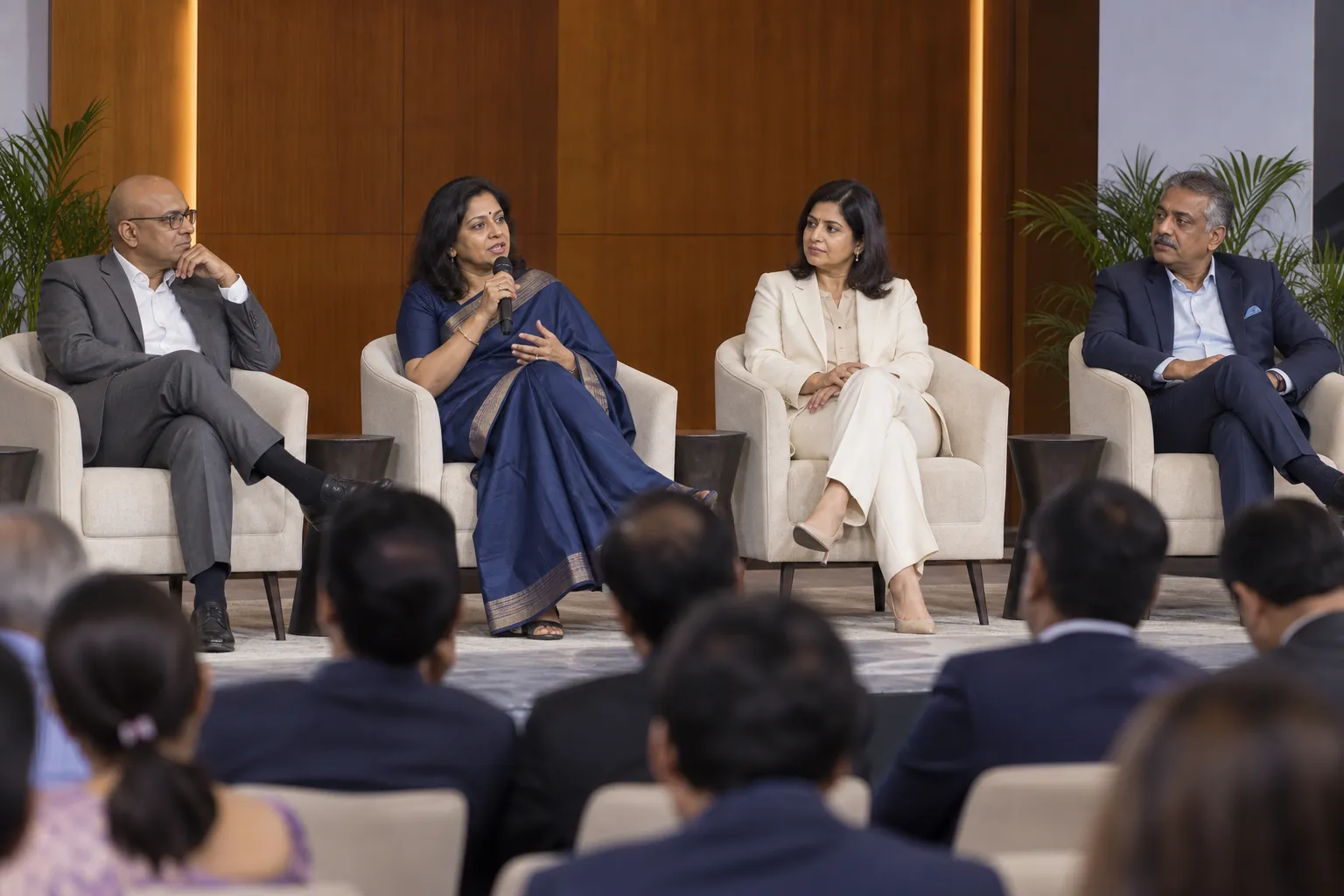 Four senior leaders in a panel discussion before an audience